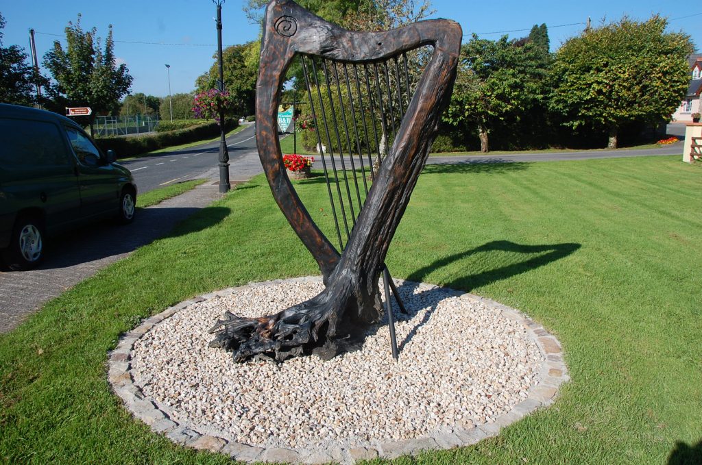 Sculpture of a harp in a landscpaed garden