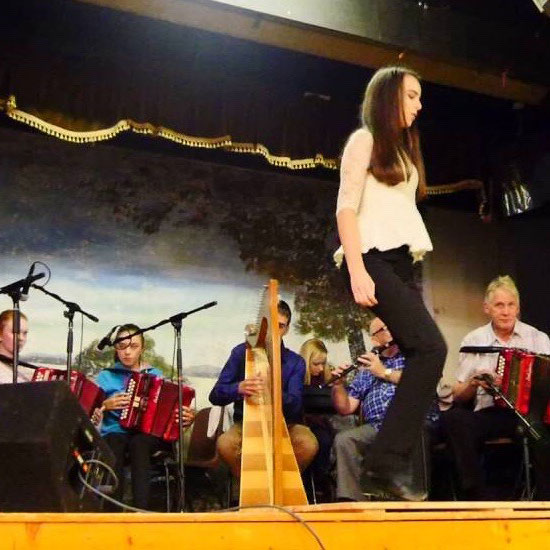 Woman dancing on stage with musicians playing in background