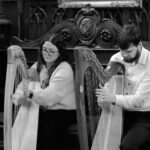 A woman and a man playing the harp
