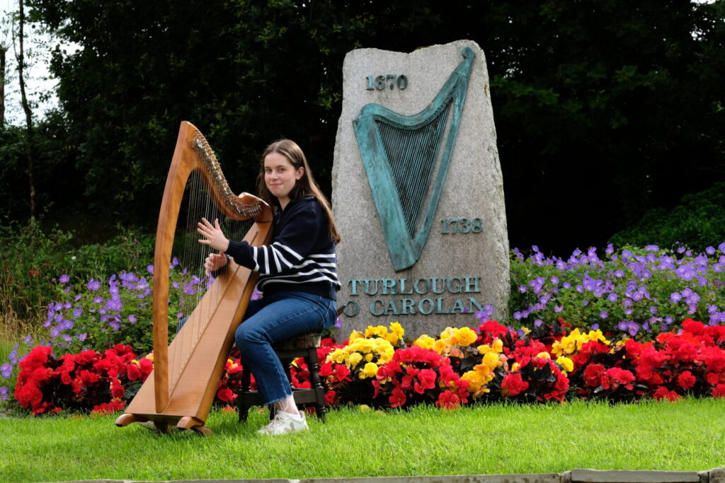 Girl playing harp in landscaped garden
