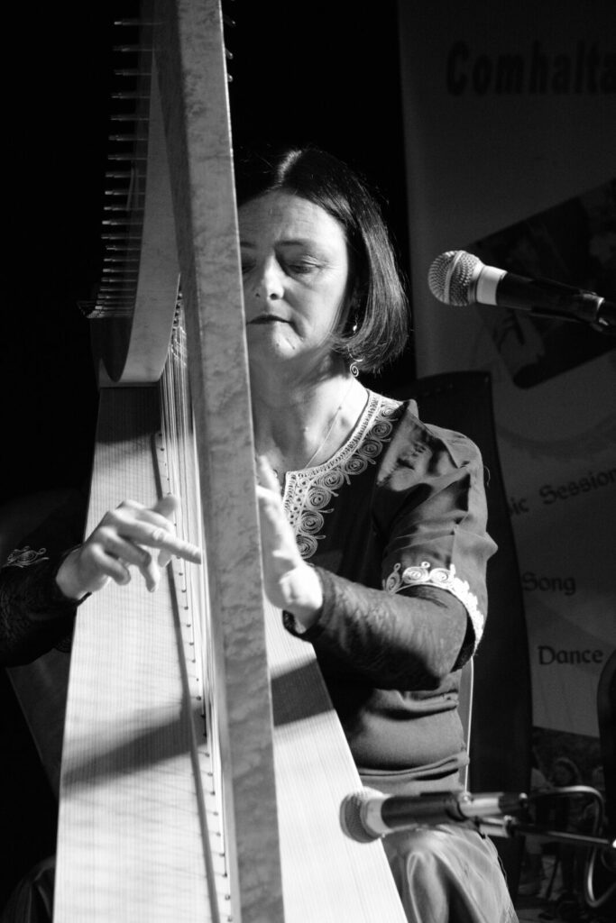 Black and white photo of woman playing harp